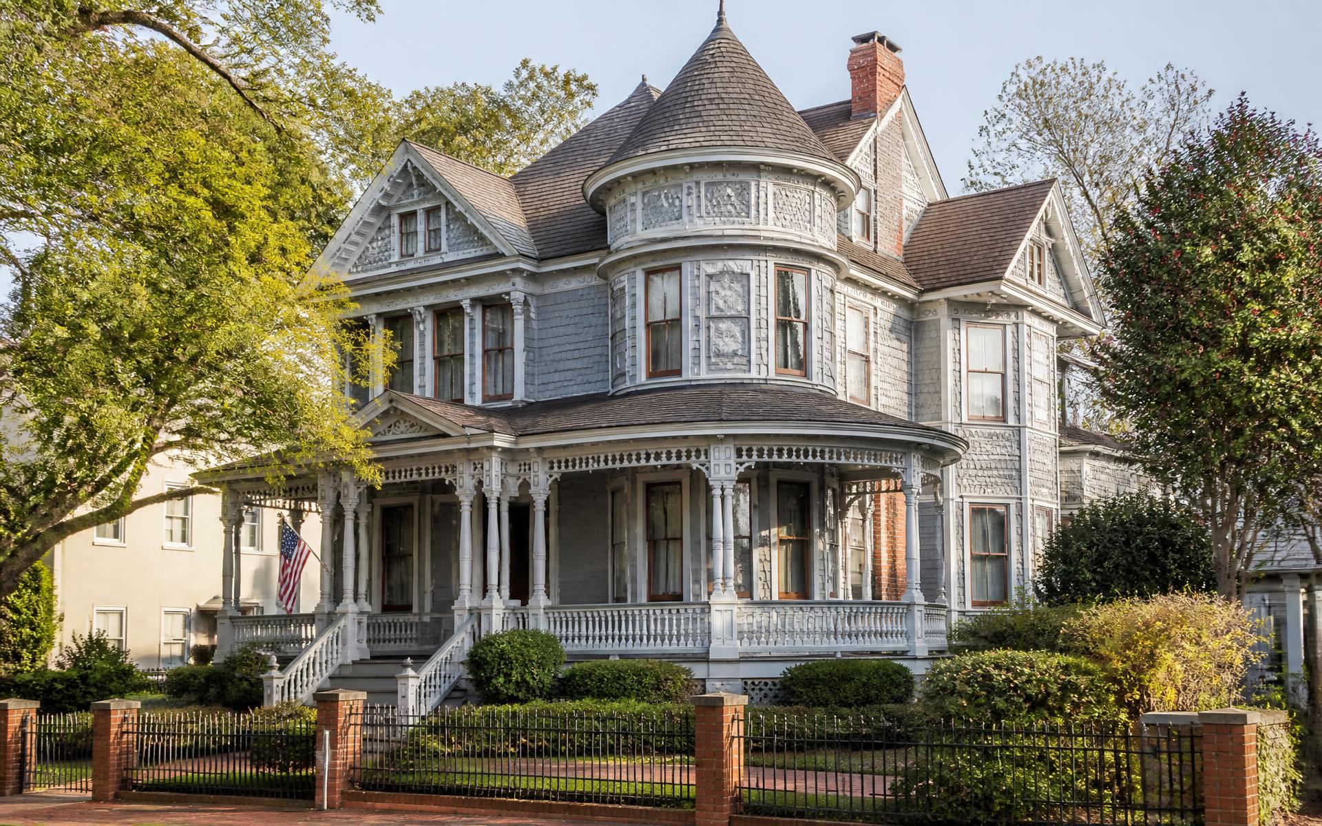 An ornate Queen Anne Victorian house with turret and spindled porch in Dilworth