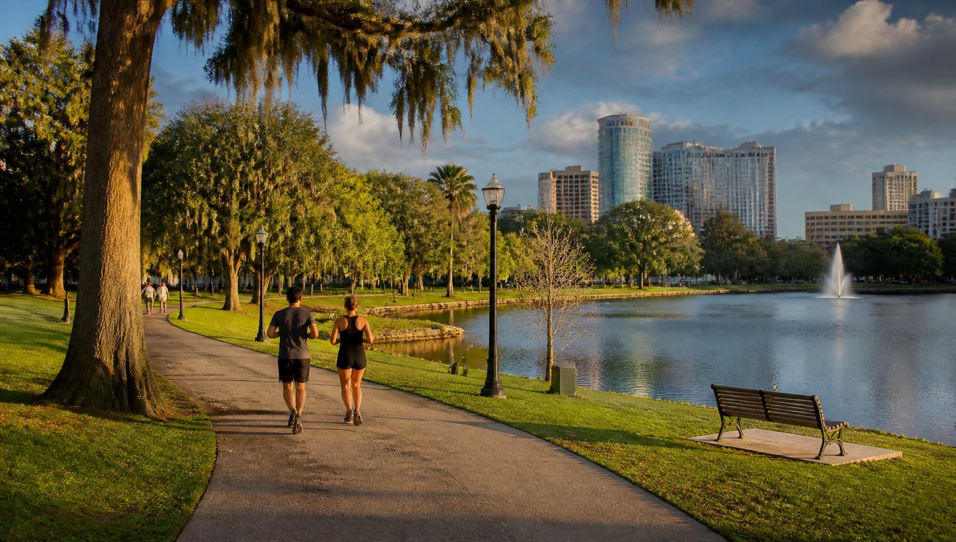 Runners on the paved loop path beside the lake at Freedom Park near Dilworth, Charlotte