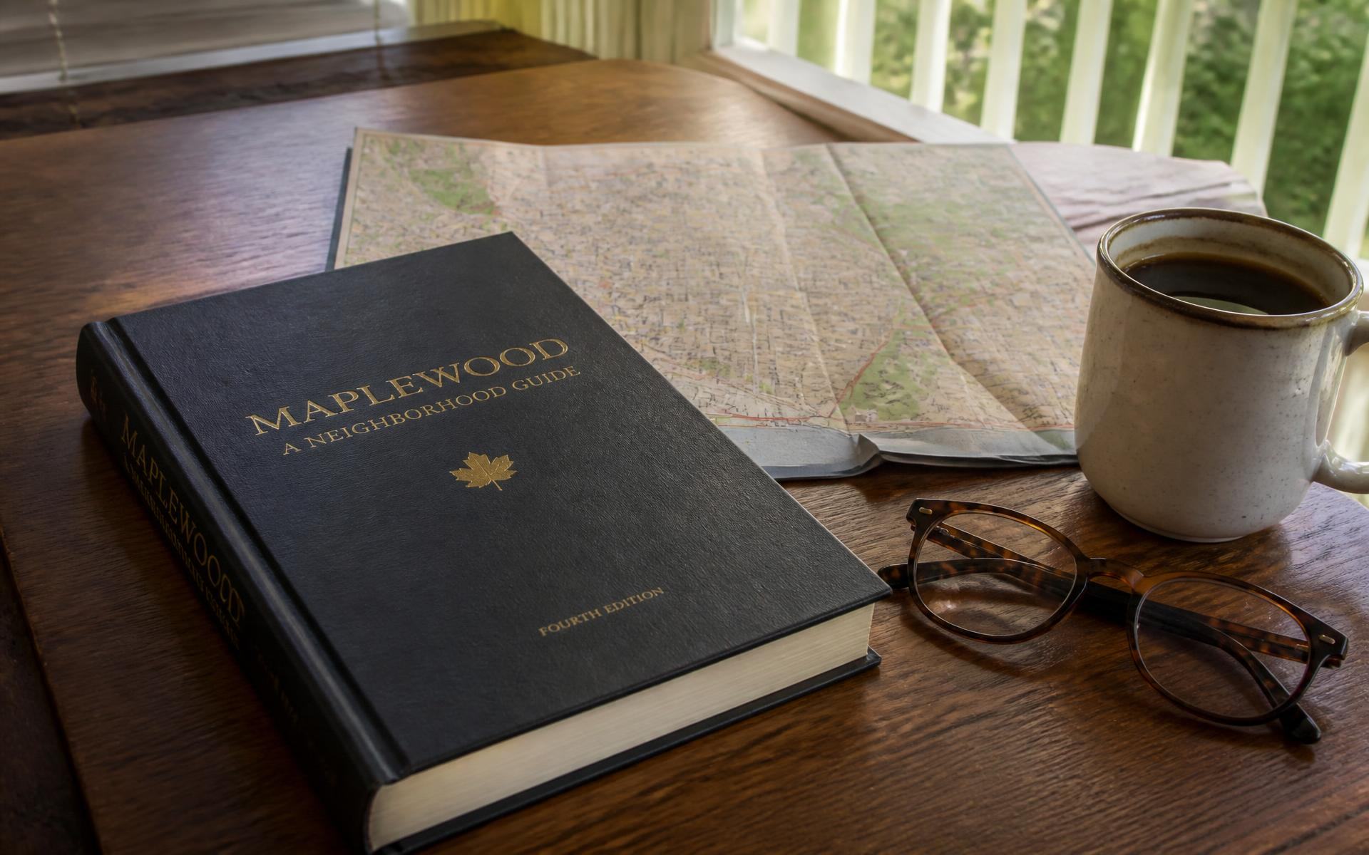 A neighborhood guidebook and folded street map on a porch table