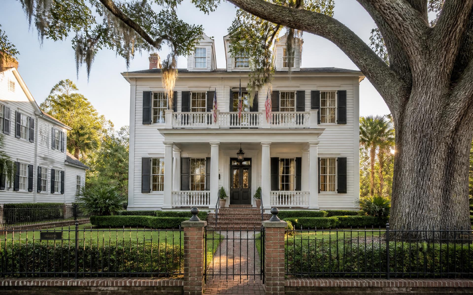 A restored historic home with manicured lawn and mature oak in Dilworth
