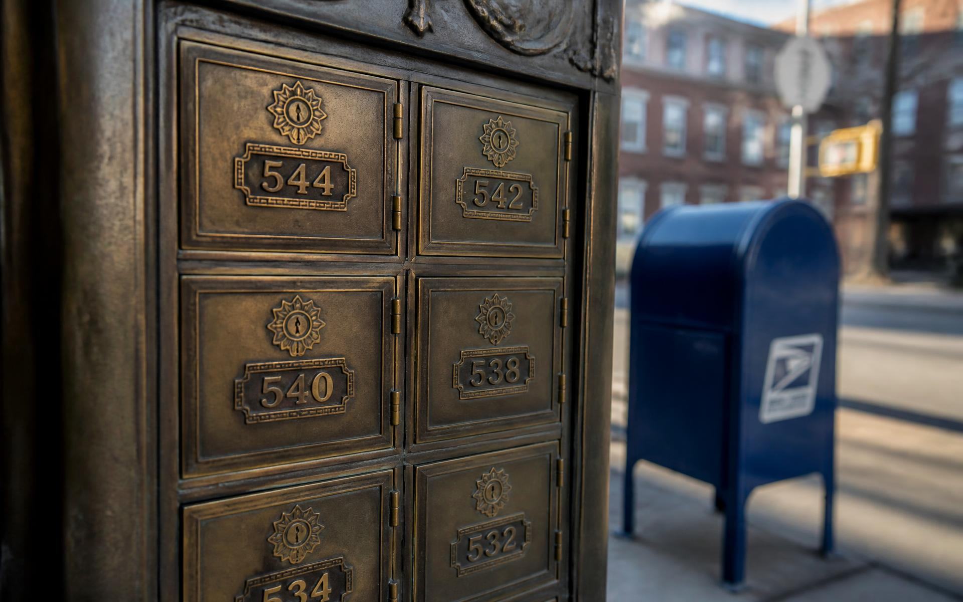 Brass mailboxes and a USPS collection box on a Dilworth street corner in 28203